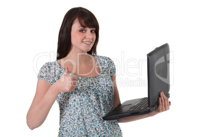 Brunette holding laptop computer and giving the thumbs-up