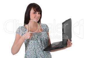 Brunette holding laptop computer and giving the thumbs-up