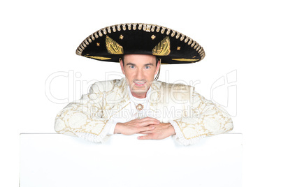 Man dressed as a mariachi with a board left blank for your message