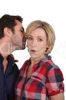 Man talking to woman's ear