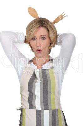 Woman with wooden spoons behind head