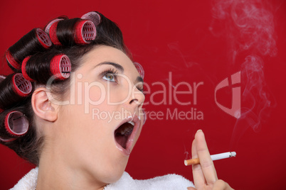 Woman wearing hair-rollers smoking