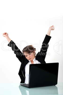 Businesswoman stretching at her laptop