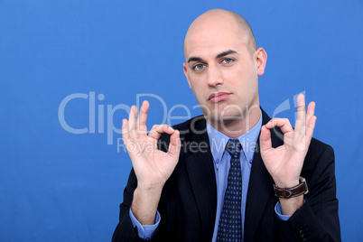 A businessman doing an ok sign.