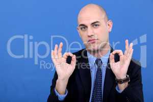 A businessman doing an ok sign.