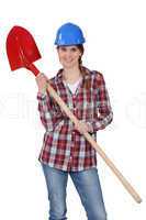 Woman wearing hard hat and holding shovel