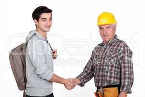 Construction worker shaking hands with a college student