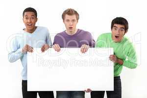 Three surprised men holding poster