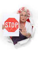 An old lady with a stop sign.