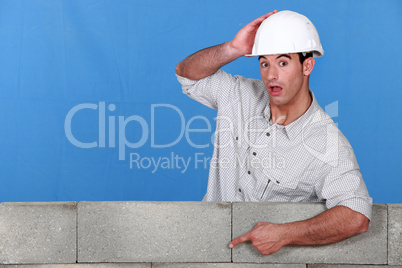 A mason pointing at a wall.