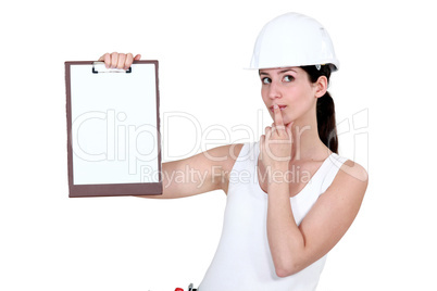 Woman with clip-board making shush gesture