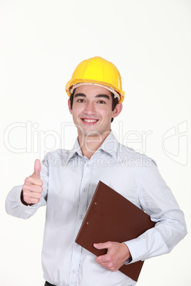 Cheerful architect with clip-board giving the thumbs-up