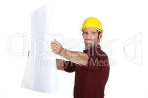 Man in a hardhat holding plans