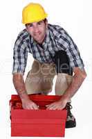 A handyman looking through his toolbox.