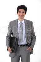 portrait of handsome young businessman all smiles with laptop