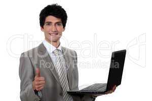 businessman holding a laptop and making a thumbs up sign