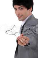 A businessman handing over his glasses.