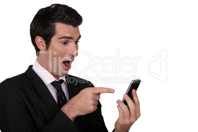 Surprised man pointing to his mobile phone
