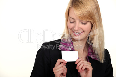 blonde businesswoman with downcast eyes showing business card