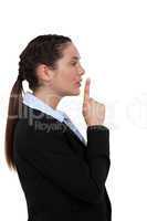 Woman holding her index finger to her lips
