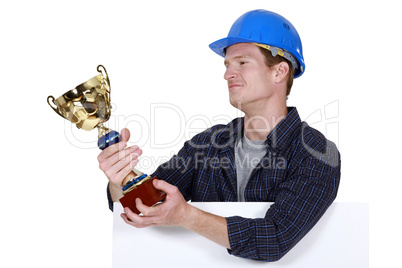 Proud builder holding trophy