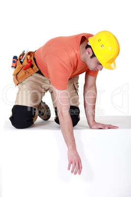 Construction worker reaching down