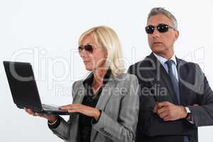 Shady mature business couple with a laptop