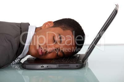 Young businessman asleep on laptop