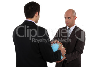 Two businessmen holding globe