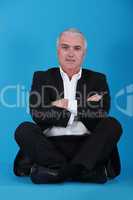 Middle-aged businessman sat cross-legged
