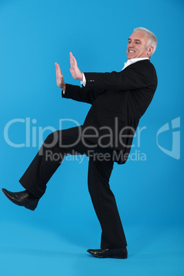 middle-aged man in suit pushing invisible furniture