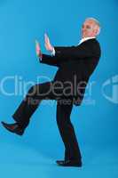 middle-aged man in suit pushing invisible furniture