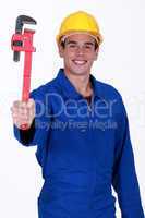 young workman in jumpsuit holding adjustable spanner