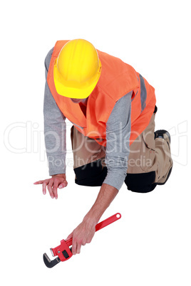 Tradesperson using a pipe wrench