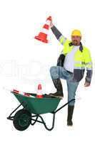 Traffic worker with cone and wheelbarrow
