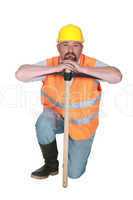 Construction worker leaning on a pickaxe