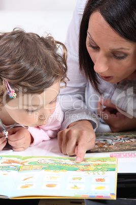 Mother teaching daughter to read