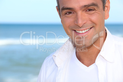 Closeup of a smiling man standing by the ocean