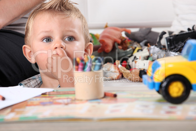 Little boy drawing with crayons