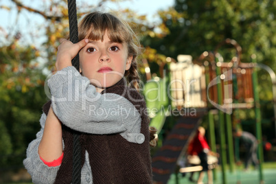 Girl holding onto a rope in a playground