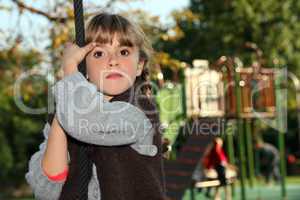 Girl holding onto a rope in a playground