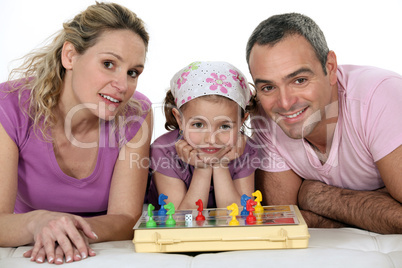 Parents and little girl playing chess together