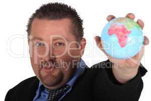 Man in suit holding globe