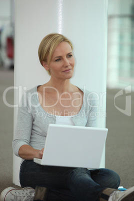Casually dressed woman using a laptop computer in a public space