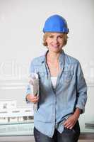 Woman in hard hat with architect's plans and model