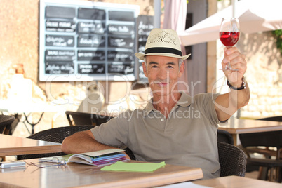 senior man toasting on a cafe terrace