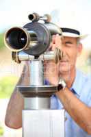 Middle-aged man looking through telescope