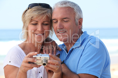 Mature couple looking at the photos on their digital camera
