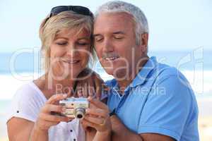 Mature couple looking at the photos on their digital camera