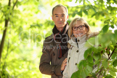 Middle-aged couple walking through park